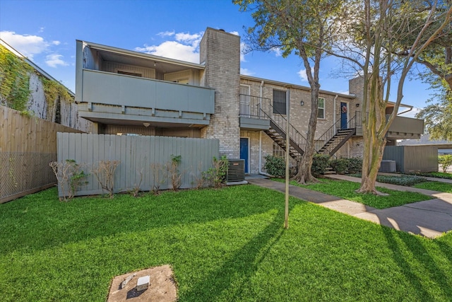 exterior space with central AC and a front lawn