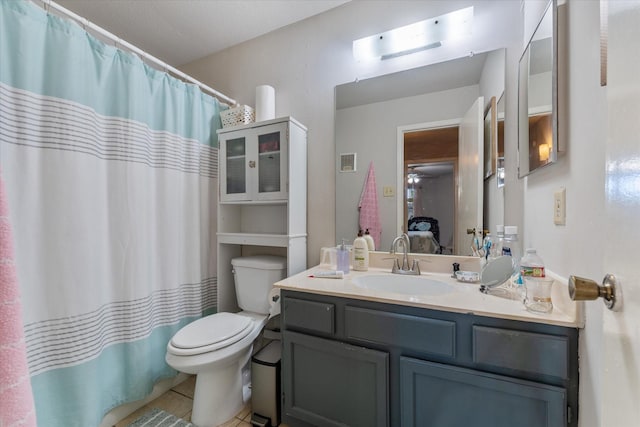 bathroom with tile patterned flooring, vanity, and toilet