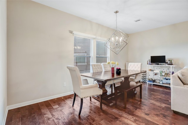 dining area with dark hardwood / wood-style floors and a chandelier