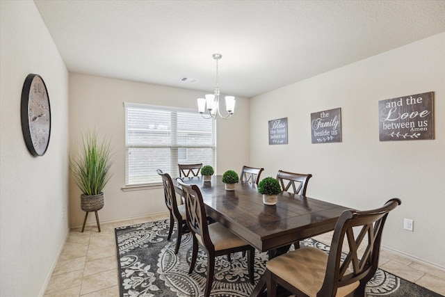 tiled dining space featuring a chandelier