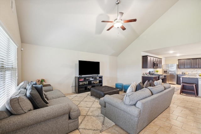 tiled living room featuring high vaulted ceiling, ceiling fan, and sink