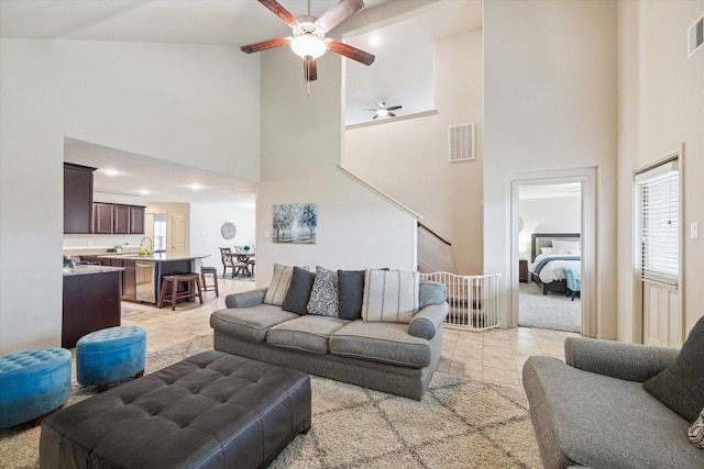 living room featuring ceiling fan, light tile patterned floors, sink, and high vaulted ceiling