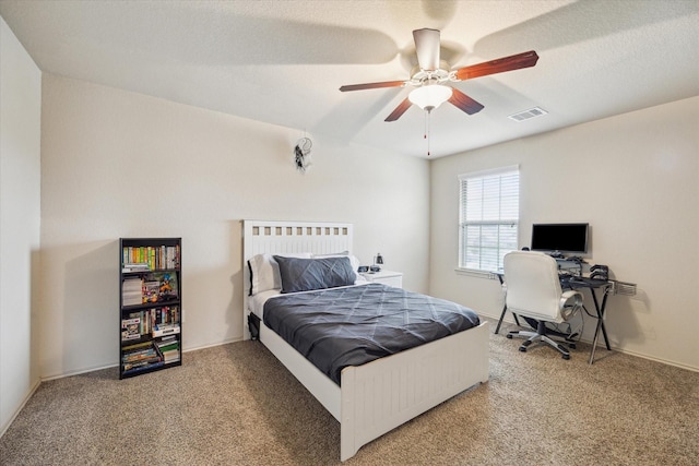 bedroom with a textured ceiling, carpet floors, and ceiling fan