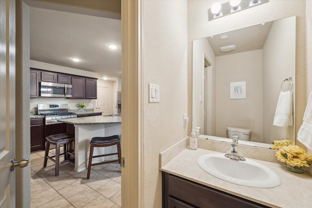 bathroom with tile patterned flooring, vanity, and toilet