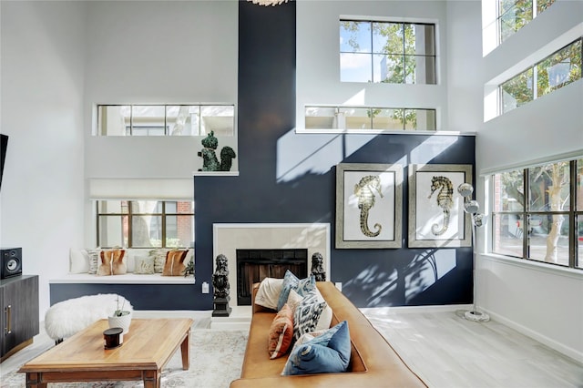 interior space with a fireplace, a high ceiling, and hardwood / wood-style floors