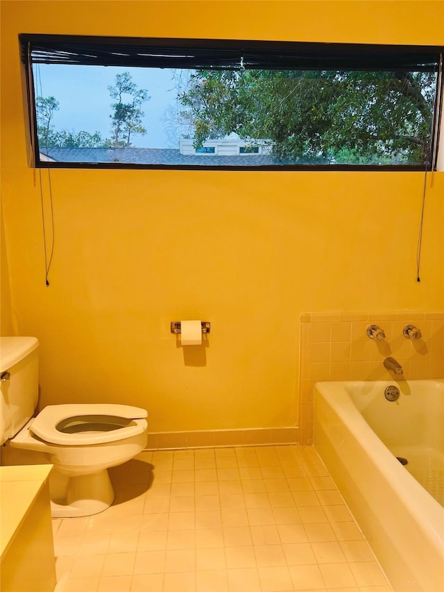 bathroom featuring tile patterned floors, a washtub, vanity, and toilet