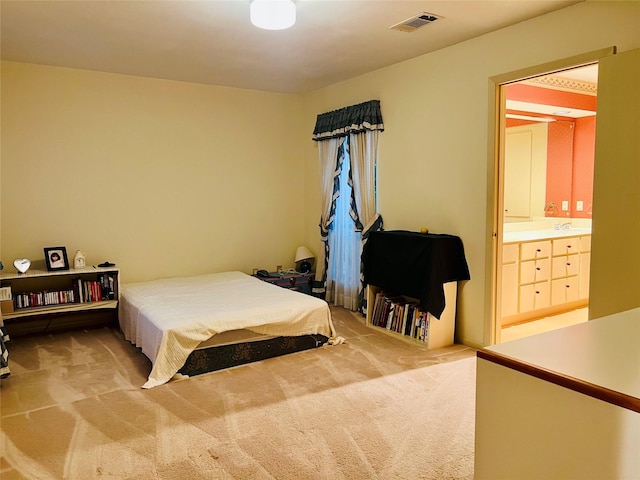 carpeted bedroom featuring ensuite bath