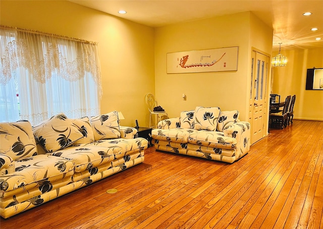 living room with a chandelier and light hardwood / wood-style floors