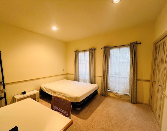 bedroom with light carpet and a closet