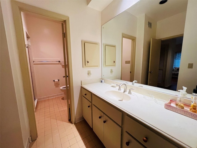 bathroom featuring toilet, vanity, tile patterned floors, and an enclosed shower