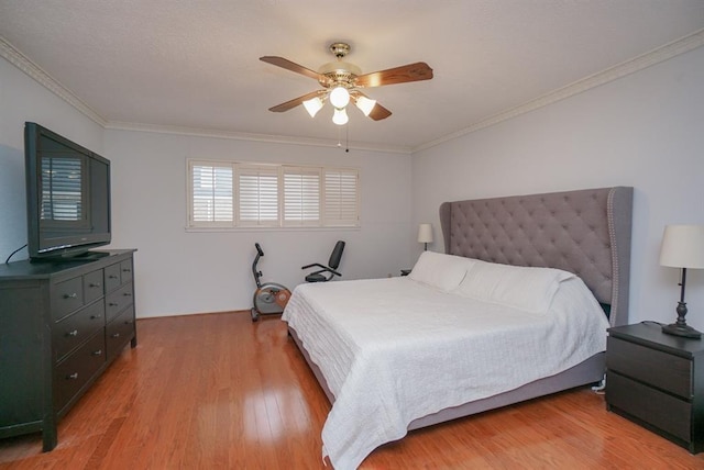 bedroom with ceiling fan, hardwood / wood-style floors, and ornamental molding