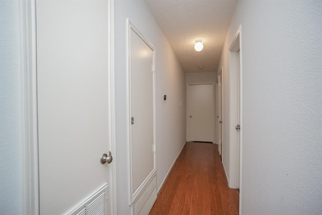 hall featuring a textured ceiling and light wood-type flooring