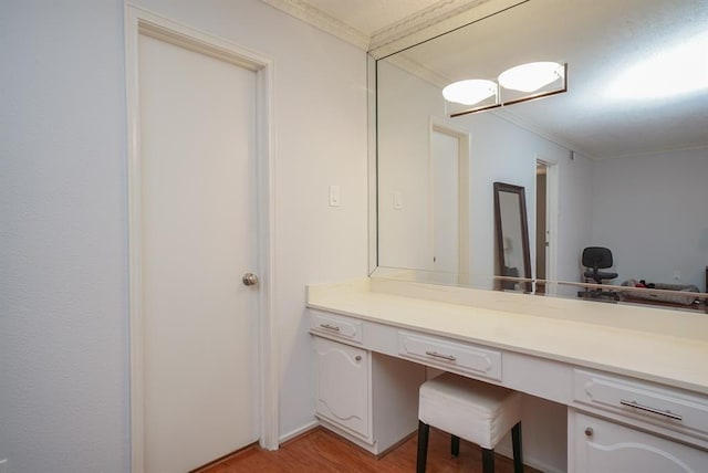 bathroom featuring vanity, wood-type flooring, and crown molding