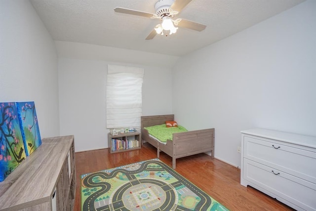 bedroom featuring ceiling fan, light hardwood / wood-style floors, and vaulted ceiling