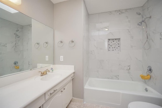 full bathroom featuring tiled shower / bath, tile patterned flooring, vanity, and toilet