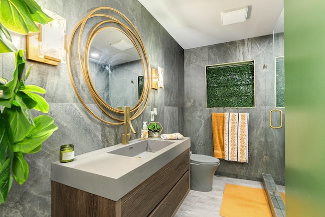 bathroom featuring walk in shower, vanity, tile walls, and toilet