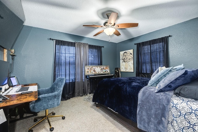 bedroom featuring ceiling fan, carpet floors, and a textured ceiling