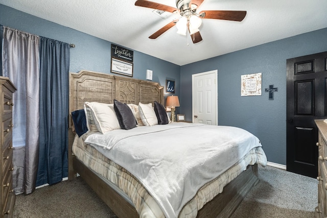 bedroom with ceiling fan, a textured ceiling, and dark colored carpet