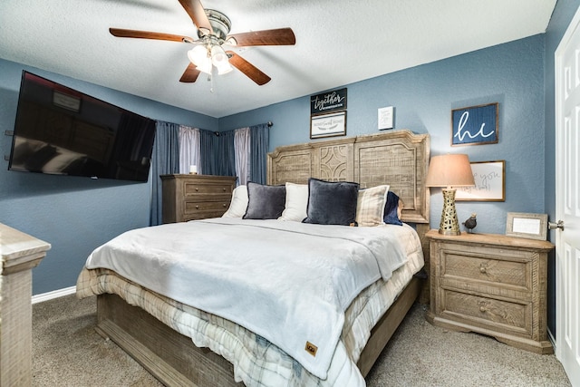 carpeted bedroom with ceiling fan and a textured ceiling