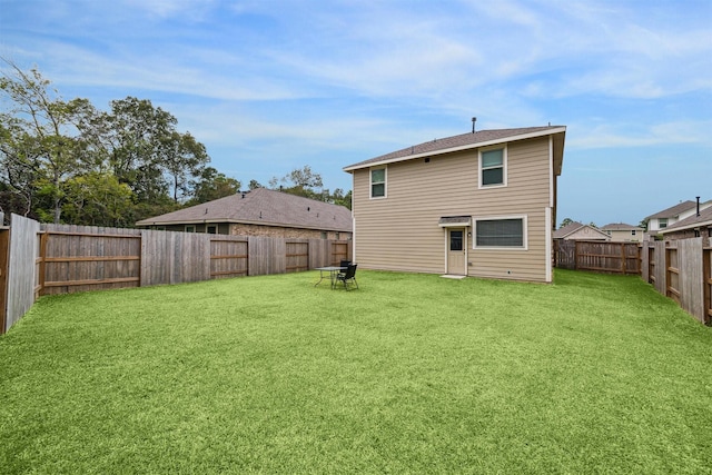 rear view of house featuring a yard