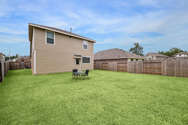 back of house featuring a lawn