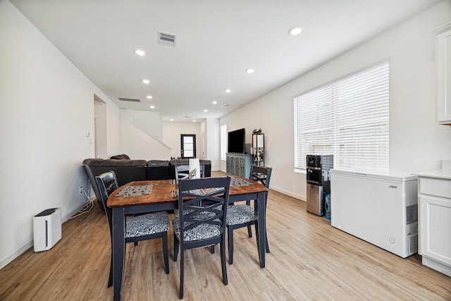 dining space with light hardwood / wood-style floors and a wealth of natural light