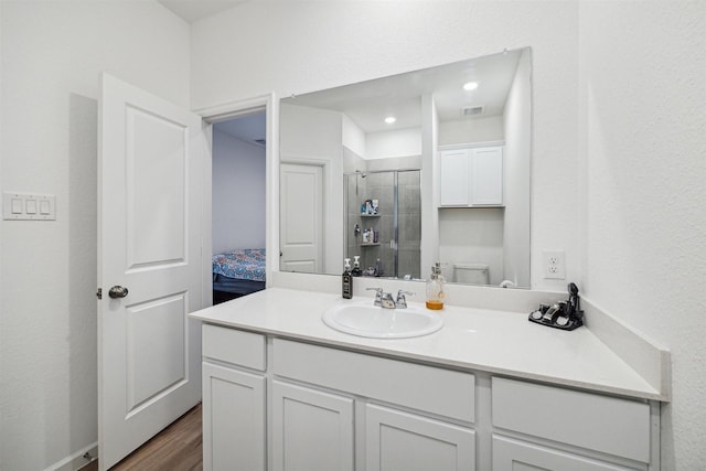 bathroom with vanity, hardwood / wood-style flooring, toilet, and a shower with shower door