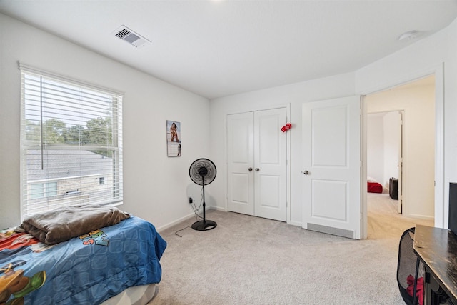 bedroom featuring light colored carpet and a closet