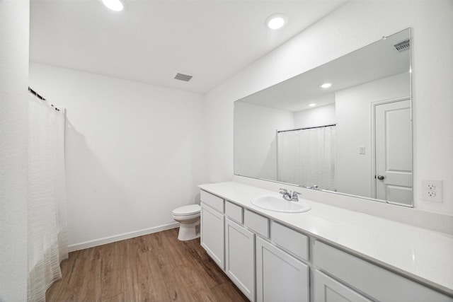 bathroom featuring toilet, vanity, and hardwood / wood-style flooring