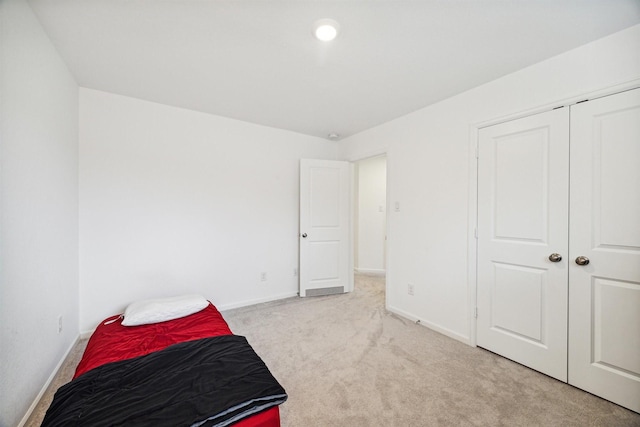 bedroom with light carpet and a closet