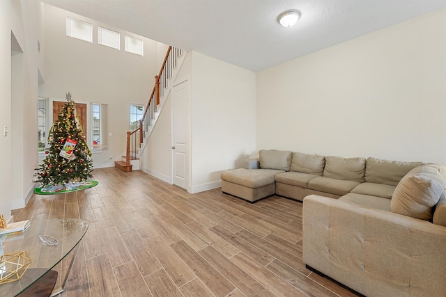 living room with a high ceiling and light wood-type flooring