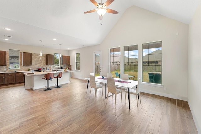 dining room with high vaulted ceiling and ceiling fan