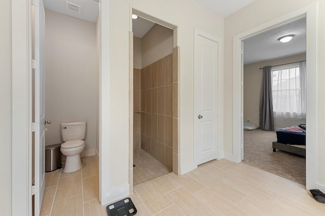 bathroom featuring a textured ceiling, toilet, and a shower