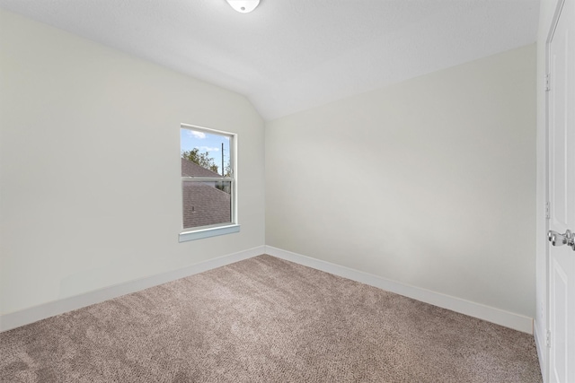 unfurnished room featuring carpet and vaulted ceiling