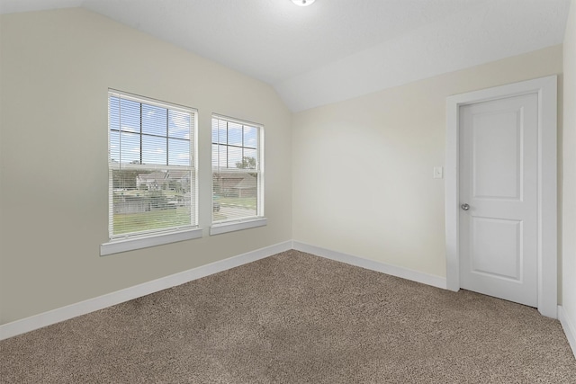 spare room featuring lofted ceiling and carpet floors