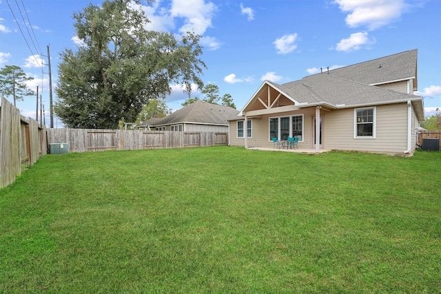 rear view of house with a yard, a patio, and central AC unit