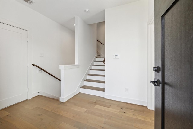 stairway featuring baseboards and wood finished floors