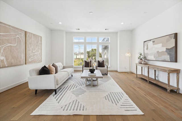 living area with recessed lighting, light wood-style flooring, and baseboards