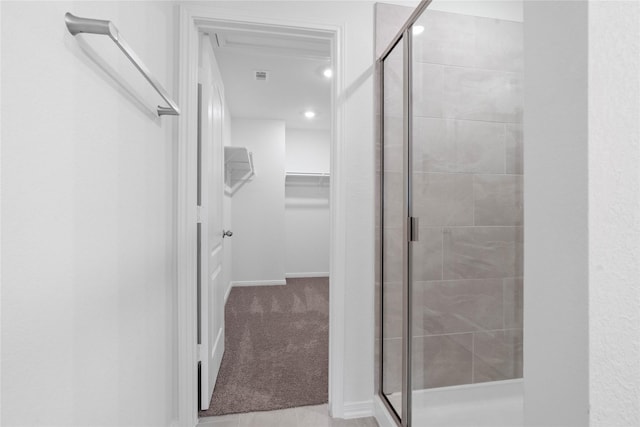 bathroom featuring a walk in closet, recessed lighting, visible vents, and a stall shower