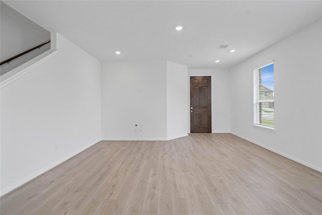 empty room featuring recessed lighting, visible vents, light wood finished floors, and baseboards
