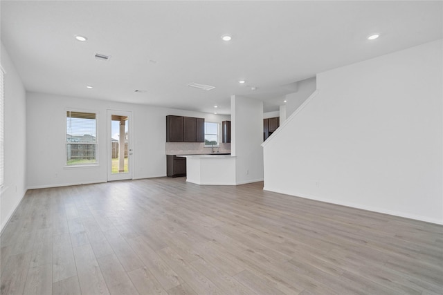 unfurnished living room with plenty of natural light, visible vents, and recessed lighting