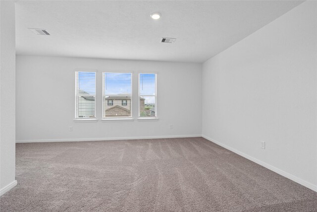 empty room with baseboards, carpet flooring, and visible vents