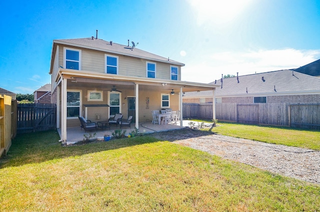 back of house featuring a lawn, ceiling fan, and a patio