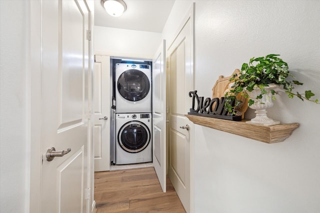 laundry area featuring stacked washer and dryer and light hardwood / wood-style floors