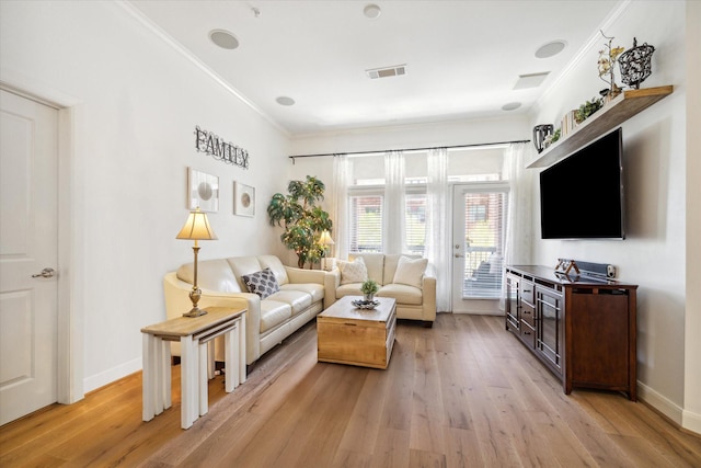 living room with light hardwood / wood-style flooring and ornamental molding