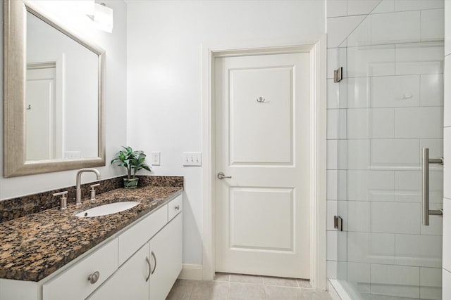 bathroom featuring tile patterned flooring, vanity, and walk in shower