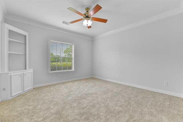 empty room with crown molding, ceiling fan, light colored carpet, and a textured ceiling