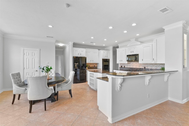 kitchen featuring white cabinetry, tasteful backsplash, kitchen peninsula, a breakfast bar, and black appliances