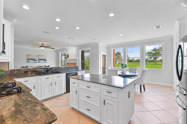 kitchen featuring ceiling fan, sink, black appliances, white cabinets, and a kitchen island