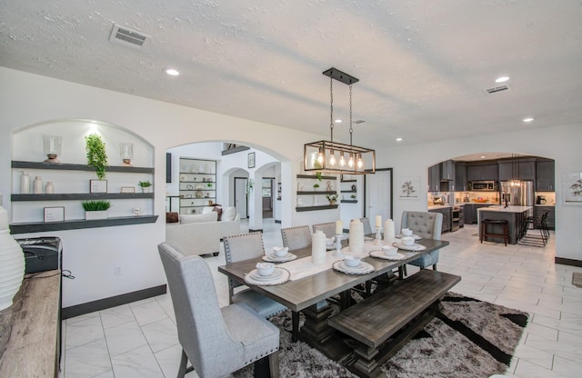 dining space with built in features and a textured ceiling